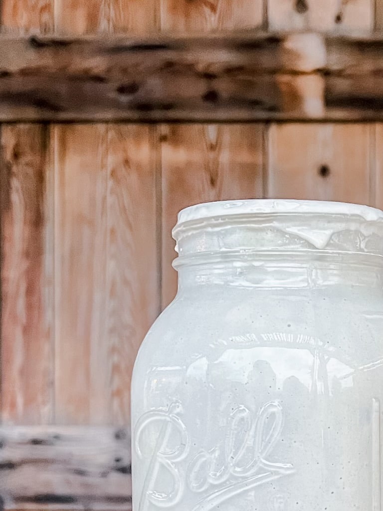 Ball canning jar with sourdough starter inside.
