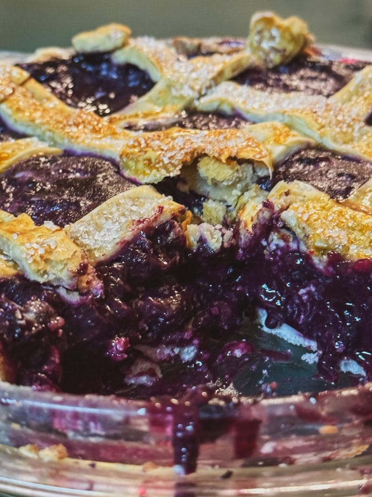 A golden, flaky pie crust filled with rich, glossy keto blueberry filling, bursting with fresh berry flavor.